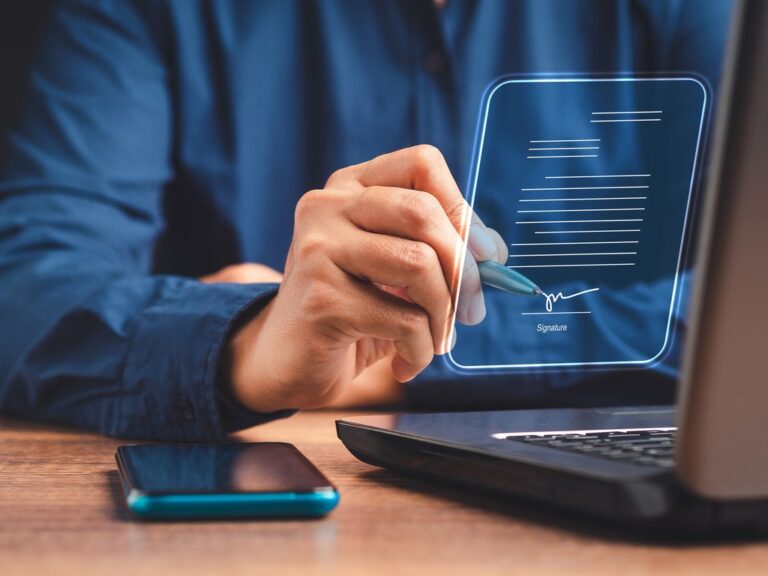Homem escrevendo num certificado digital, feito com efeito 3D acima de um teclado de notebook, simbolizando quanto tempo demora para tirar certificado digital